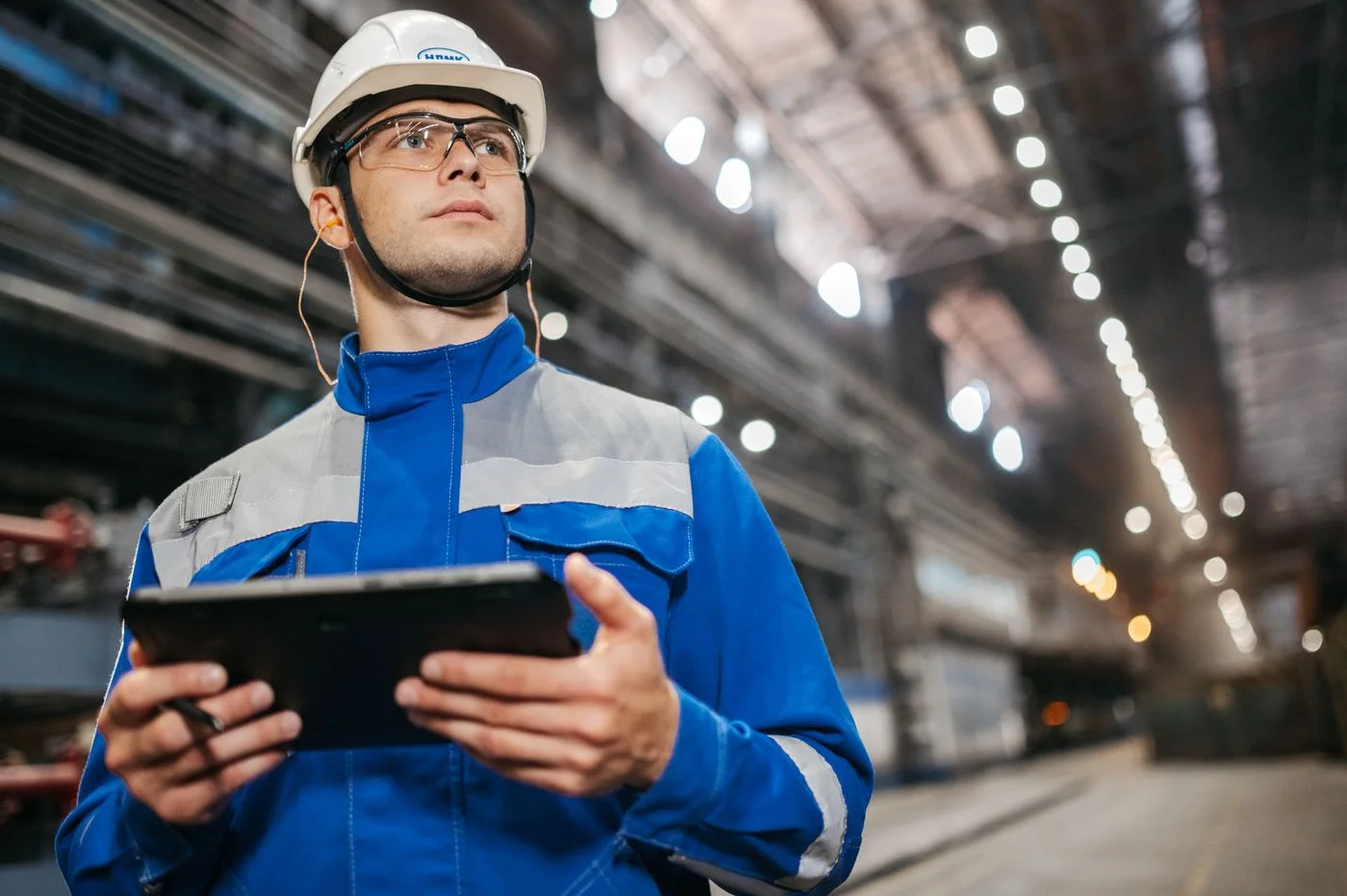Engenheiro realizando inspeção com tablet em ambiente industrial portuário